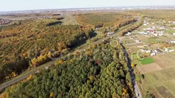 空中观景台飞过马路田野和美丽的秋树视频的预览图