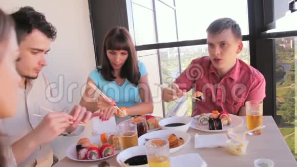 三个朋友在露台上用筷子吃亚洲菜视频的预览图