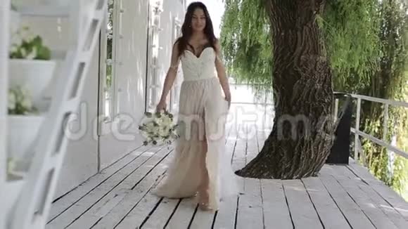 带着花束的新娘走在湖边慢动作视频的预览图