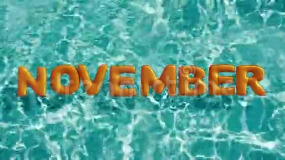 单词11月形状的充气游泳圈漂浮在一个清爽的蓝色游泳池里视频的预览图
