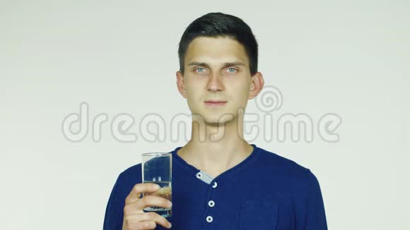一个男人从白色背景的玻璃杯里喝水视频的预览图