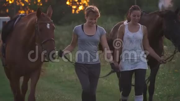 2两个女孩在田间道上骑两匹马视频的预览图
