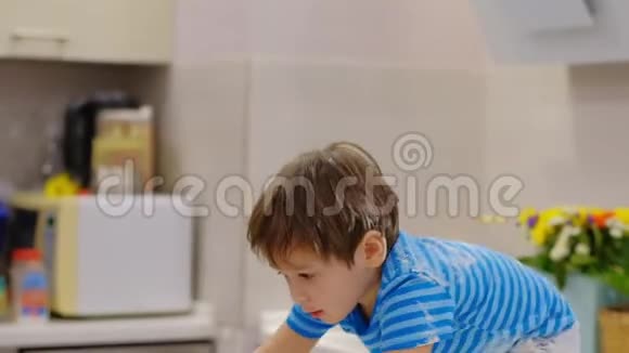 有趣的男孩在厨房里玩面粉家里的麻烦孩子淘气的孩子视频的预览图