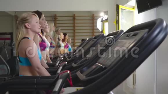 穿着运动服的苗条女性在跑步机上行走向前看动作缓慢视频的预览图