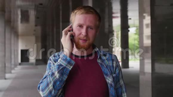 一个年轻的学生去大学打电话年轻的商人在打电话穿格子衬衫的男人视频的预览图