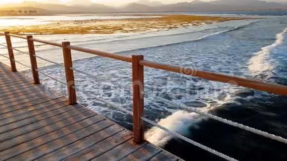 海洋中长木墩的4K视频海浪在海岸上翻滚视频的预览图