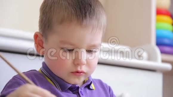 勤奋的孩子坐在桌子上画彩色颜料视频的预览图