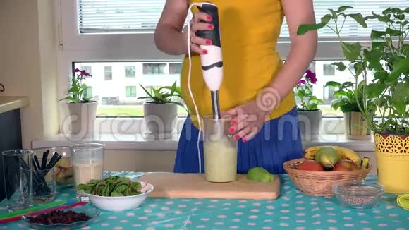 准妈妈的肚皮和手混合牛奶和有机水果鸡尾酒与搅拌机视频的预览图