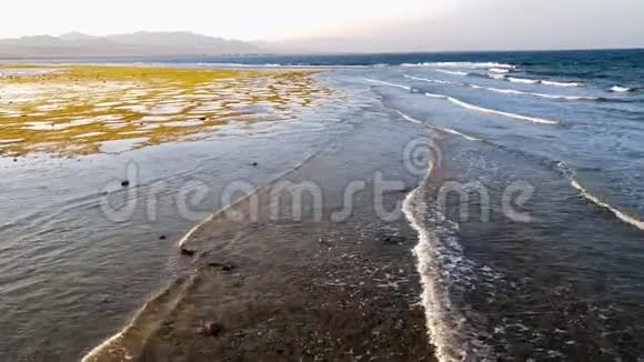 日落时海浪翻过海岸线的4k镜头视频的预览图