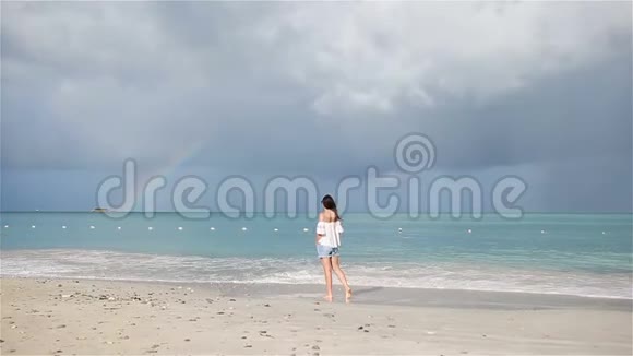 热带海滨的年轻美女背景是彩虹快乐女孩在白沙热带海滩放松视频的预览图