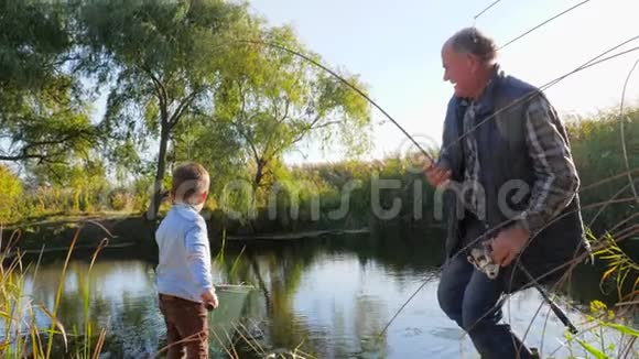 春天在湖上钓鱼爷爷和孙子在户外玩得很开心视频的预览图