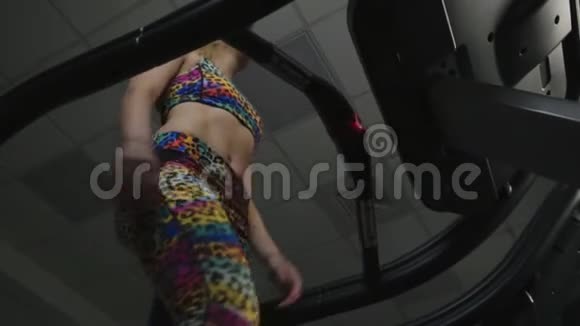 一个穿着运动服在跑步机上行走的女孩的底图视频的预览图