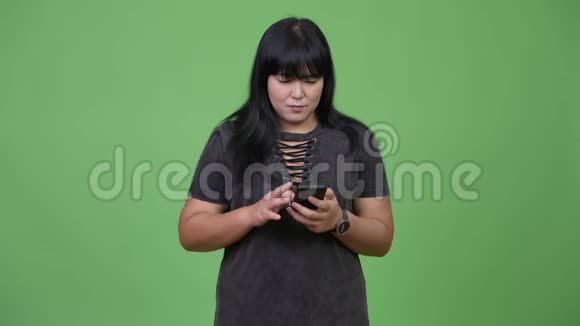 美丽超重的亚洲女人用电话得到好消息视频的预览图