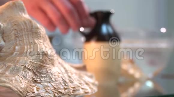 把贝壳上的油放在一个女人带按摩治疗师的瓶子上视频的预览图