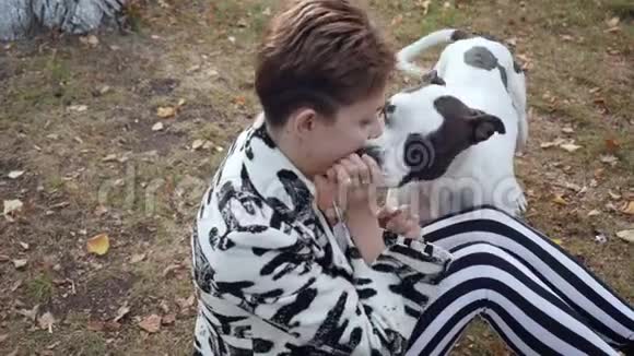 女人坐在地上拥抱她的斯塔福德狗视频的预览图