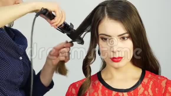 专业美发师制作卷发使用卷发棒时尚行业化妆品视频的预览图