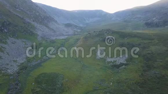 郁郁葱葱美丽的绿色山谷和悬崖鸟瞰剪辑在陡峭的山坡上向群山飞去视频的预览图