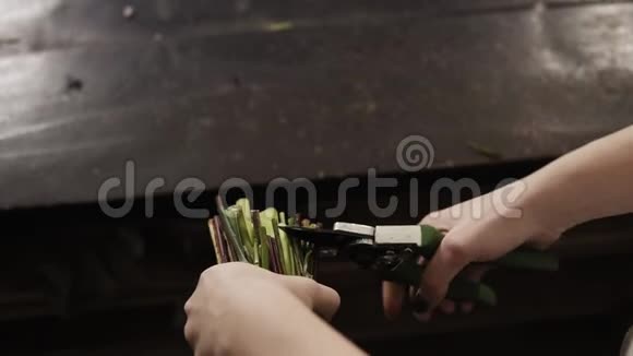 精致的雌性的手用子切花的茎切块掉在地板上瞄准射击视频的预览图