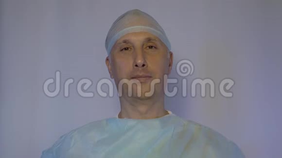 一位白人医生在手术前戴上医疗面罩他对病人的态度是积极的视频的预览图