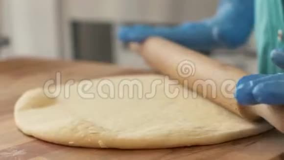 手比萨饼师在桌子上擀面团以便在餐厅里烤熟视频的预览图