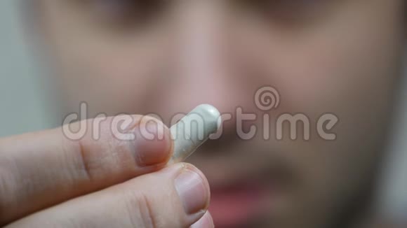 一个人把一颗药丸放进嘴里的极端近距离人拿着一杯水的药片视频的预览图