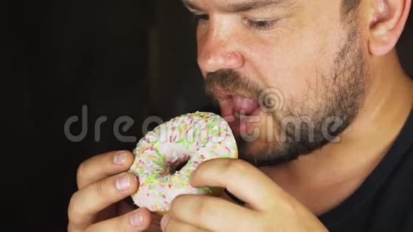 一个饥饿的年轻人吃甜甜圈的肖像视频的预览图