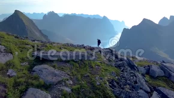 背着背包的女孩站在山脊上视频的预览图