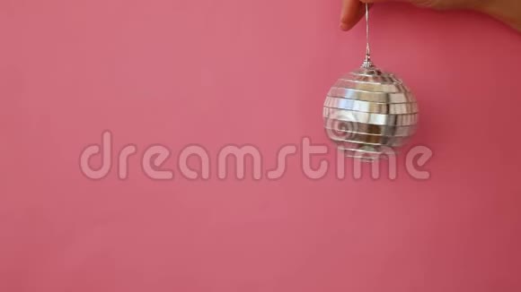 简单的最小设计女性手拿圣诞装饰迪斯科舞厅隔离在粉红色的粉彩色彩时髦视频的预览图