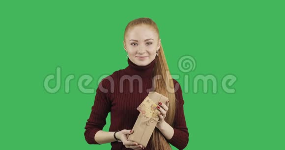 一头红色长发的女性白种人模特正在双手伸展手里拿着一个礼物盒视频的预览图