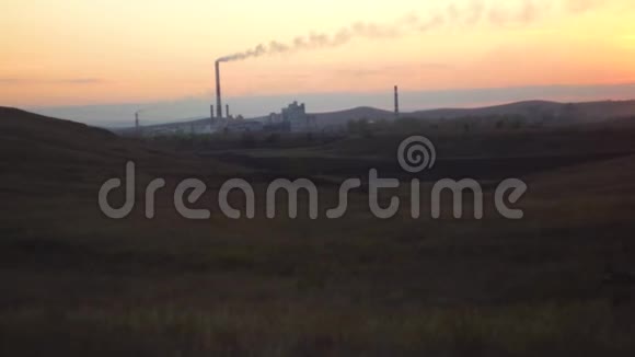 与工业企业的前景日落时草原田里的工业植物观现代概念视频的预览图