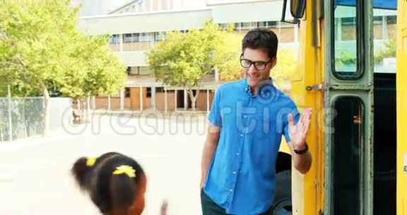上学的孩子在进公共汽车时给老师打五高视频的预览图