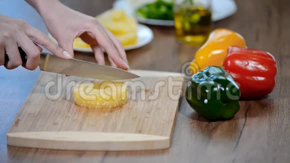 女性手在木板上切割菠萝视频的预览图