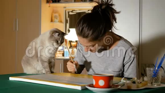 艺术家试图在家里画一幅画但她的猫阻止了她这样做有趣可爱的动物家养宠物视频的预览图