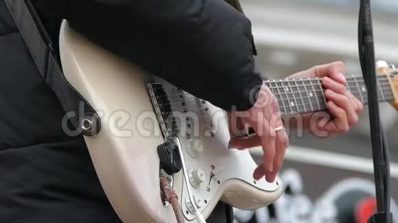 一个男人用白色的身体弹奏电吉他弦慢动作视频的预览图