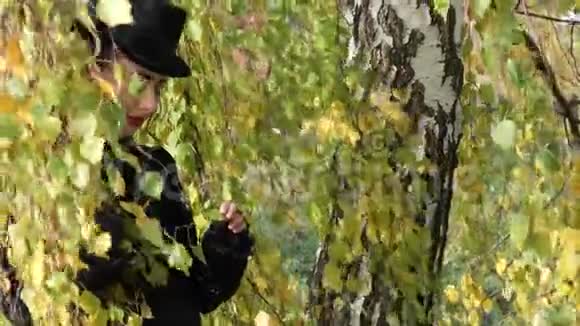 秋天穿着白桦树枝的黑裙子的女孩视频的预览图