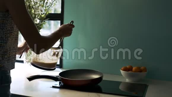 女人在厨房的热锅上放饼干面包视频的预览图