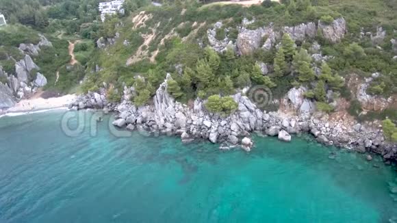 希腊阿吉亚帕拉斯凯维哈尔基迪基地区的岩石和树木旁有绿松石水的小海滩鸟瞰图视频的预览图