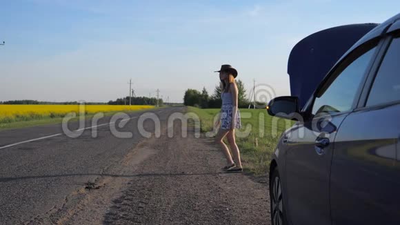 一个戴牛仔帽的小女孩正在她那辆破车的背景上追车视频的预览图