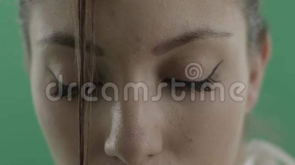 美丽的年轻女子脸上沾着绿色的头发视频的预览图