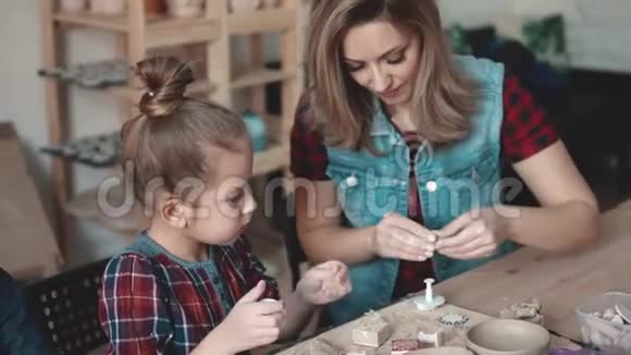 妈妈和女儿正在用粘土做工艺品陶艺课这孩子热衷于创造性的工作视频的预览图