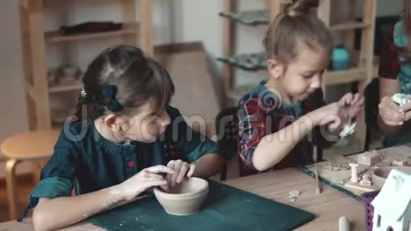 陶艺课孩子们热衷于用粘土塑造妈妈和两个女儿在一起创作视频的预览图