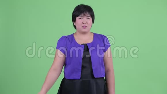 快乐年轻美丽超重的亚洲女人指着相机视频的预览图