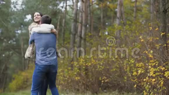 浪漫的年轻夫妇在森林里拥抱和旋转4K视频的预览图
