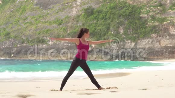 做瑜伽的女人特里科纳萨纳姿势海洋背景视频的预览图