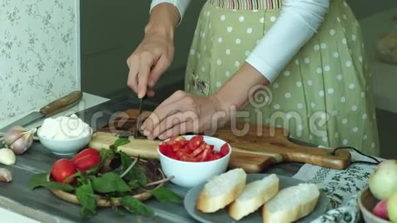 一个女人手的特写镜头是用面包奶酪和蔬菜为一个意大利的布鲁切塔准备的视频的预览图