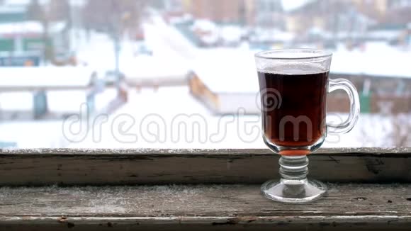 旧的木制窗台上的玻璃杯上落下的雪视频的预览图