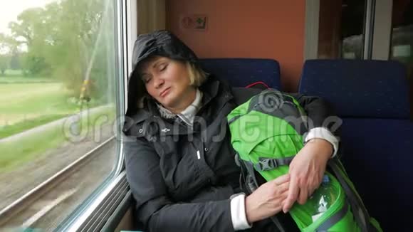 疲惫的女人坐火车靠窗睡觉视频的预览图