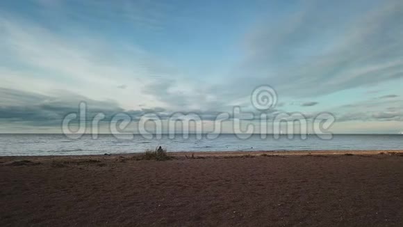 照相机从沙滩上升起日落时海滩大海和天空中的云彩是可见的视频的预览图