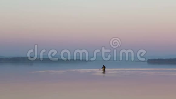 一名渔民在俄罗斯普里莫尔斯基克拉伊的阿穆斯基湾安装渔具背景是一片红色的日落天空视频的预览图