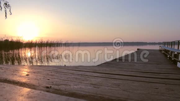 一个人的剪影走向湖边的码头走向日出视频的预览图